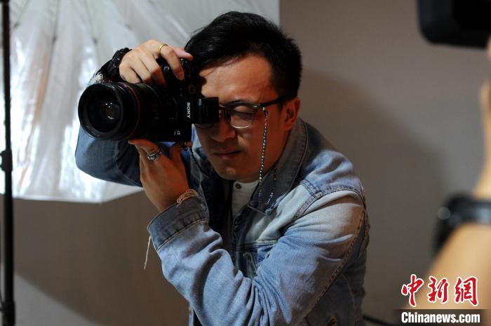 蔡鶴立在他的工作室為客人攝影。　張金川 攝