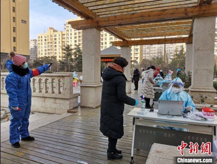 圖為社區(qū)工作人員在維持秩序。　屈冠華 攝