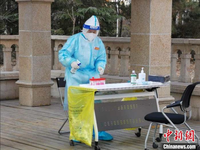 圖為醫(yī)務(wù)工作者在核酸檢測(cè)前進(jìn)行消毒工作。　屈冠華 攝