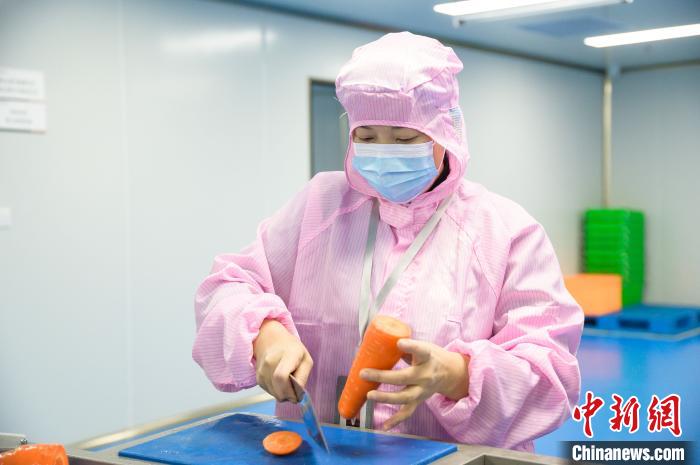 車間內(nèi)，工作人員正在處理蔬菜?！±钅宪?攝