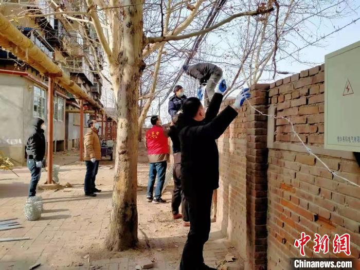 圖為小區(qū)志愿者為小區(qū)圍墻加裝倒刺鐵網(wǎng)?！〈迺?huì)芹 攝