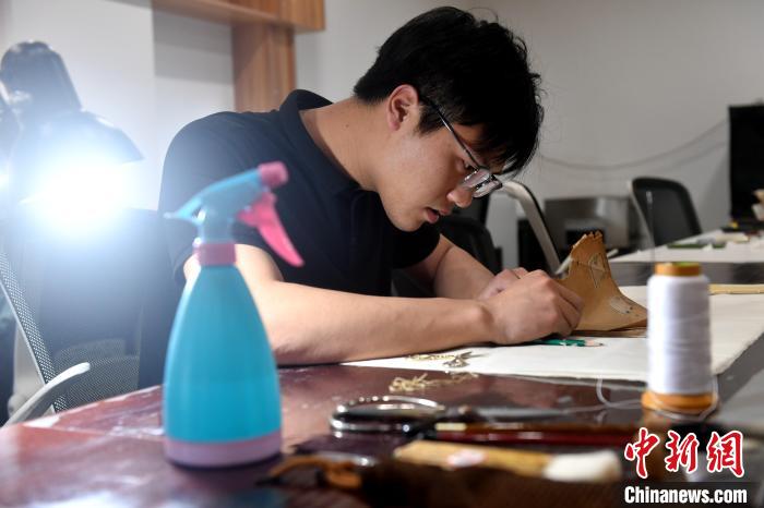 “90后”文物修復(fù)師瞿超正低頭手工修復(fù)民國(guó)時(shí)期影印的古籍《春秋繁露》。　呂明 攝