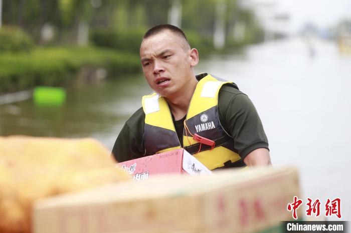 圖為賀樂(lè)在抗洪一線搬運(yùn)救災(zāi)物資?！』魜喥?攝