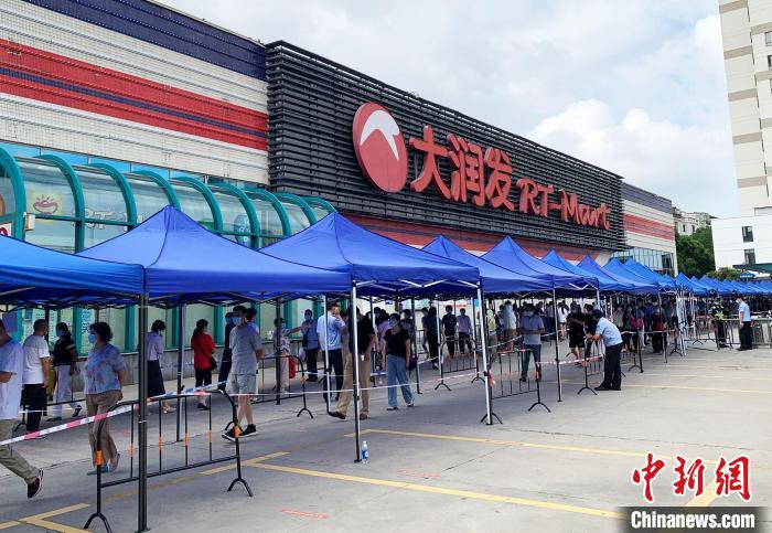 民眾排著長(zhǎng)長(zhǎng)的隊(duì)伍，在工作人員的指引下，等待進(jìn)入超市購(gòu)物。　崔佳明 攝