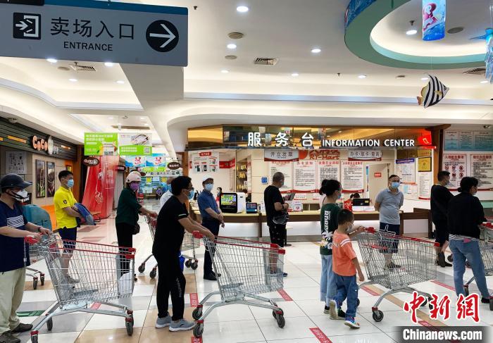 民眾戴著口罩，有序排隊(duì)，等待進(jìn)入超市購(gòu)物?！〈藜衙?攝