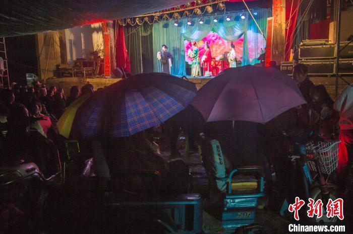 民眾在雨中觀看蒲劇?！∥淇〗?攝