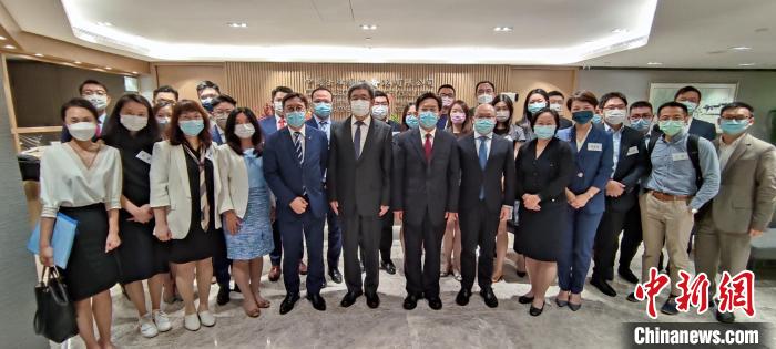 香港中聯(lián)辦秘書長王松苗一行與“港漂”律師們合影。　香港中聯(lián)辦供圖