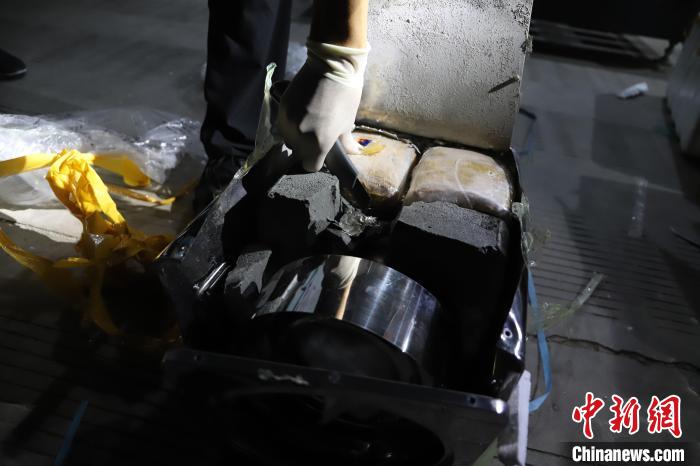 圖為民警從火爐中查獲毒品?！∥麟p版納邊境管理支隊供圖