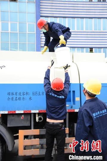 疫情期間，藍(lán)保公司員工正在裝運(yùn)捐贈(zèng)的桶裝次氯酸84消毒液(資料圖)。　陳嘉斌供圖