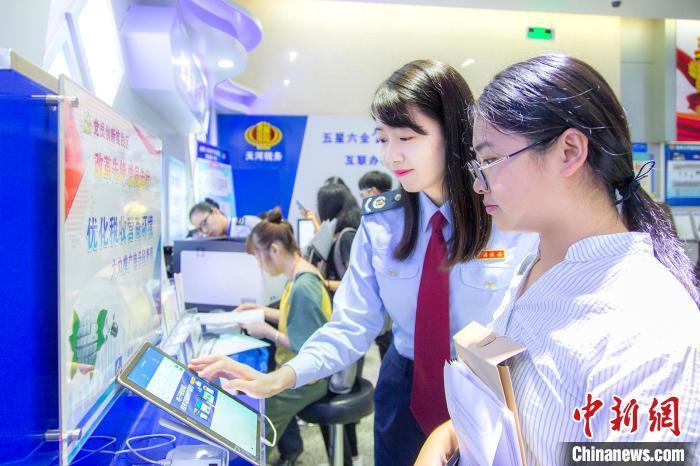 資料圖：稅務(wù)人員幫助納稅人通過電子稅務(wù)辦理業(yè)務(wù)。　楊銳軒 攝
