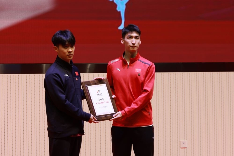 武大靖為青年歌手馬伯騫頒發(fā)“冰雪運動推廣大使”證書。新華社記者 季嘉東 攝