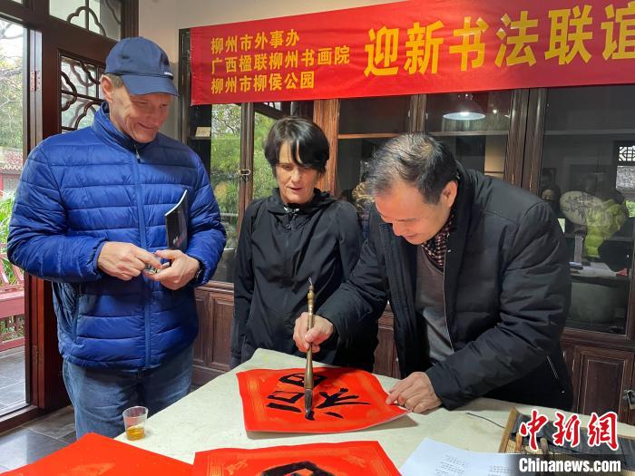 柳州市一書法家教兩位英國人書寫春聯(lián)?！×周?攝