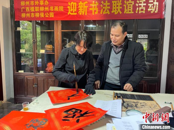 圖為一名英國人體驗寫春聯(lián)?！×周?攝