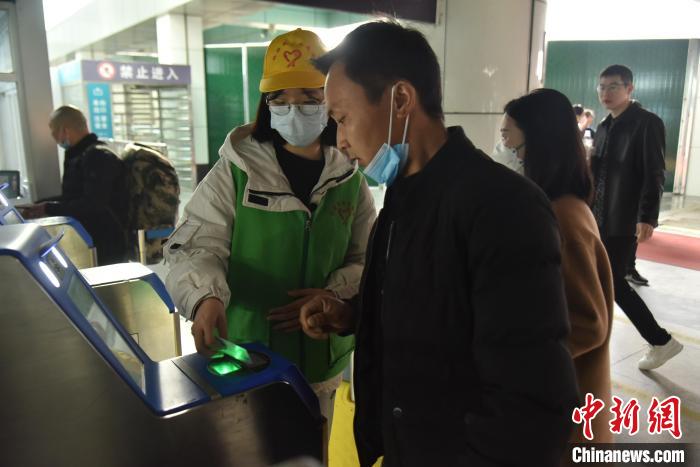 圖為志愿者協(xié)助乘客?！№n毅 攝