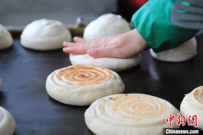 “火燒”師傅把半成品放在鐵板上旋磨成型后壓平?！∴囆?qiáng) 攝