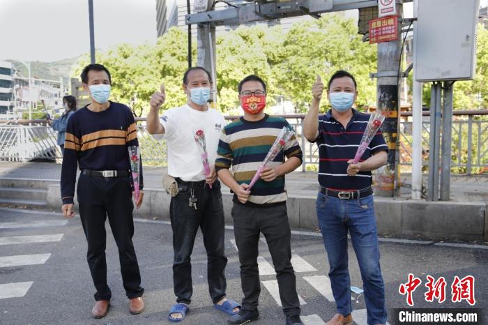 市民手持康乃馨為解封“點贊”?！￡愌欧?攝