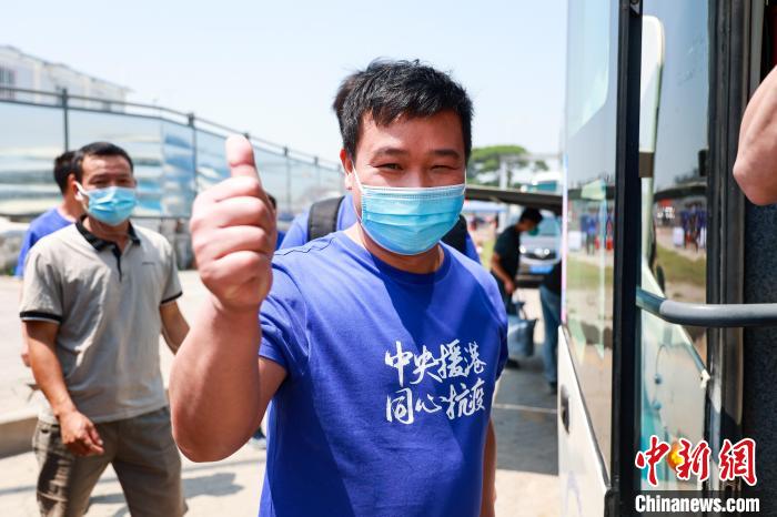 建設(shè)者們身穿文化衫，帶著燦爛的笑容離開(kāi)駐地?！≠Z凱 攝