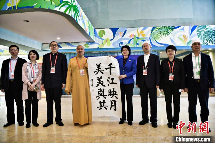 座談結(jié)束后，中國佛教協(xié)會副會長、海南省佛教協(xié)會會長印順(左四)向苻彩香(右四)贈送書法作品?！⊥鯐员?攝