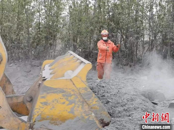 一名負(fù)責(zé)觀察鏟斗的消防員正在指揮裝載機(jī)作業(yè)?！↓R帥 攝