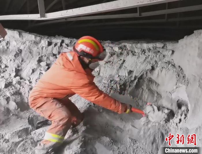 一名消防員單腿跪在粉煤灰堆上搜救被困人員?！↓R帥 攝