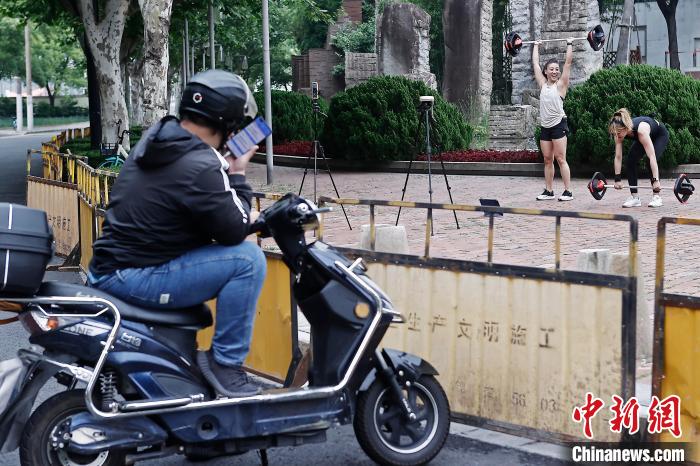 市民在防范區(qū)街頭空曠的場(chǎng)地上鍛煉，路過的快遞員停車觀看?！∫罅⑶?攝