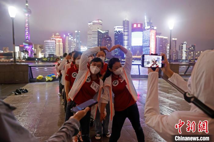 華中科技大學同濟醫(yī)學院附屬同濟醫(yī)院援滬醫(yī)療隊隊員冒雨在外灘濱江步道上擺造型合影?！∫罅⑶?攝