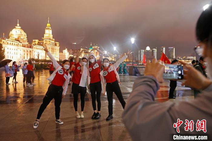 華中科技大學同濟醫(yī)學院附屬同濟醫(yī)院援滬醫(yī)療隊隊員冒雨在外灘濱江步道上擺造型合影?！∫罅⑶?攝