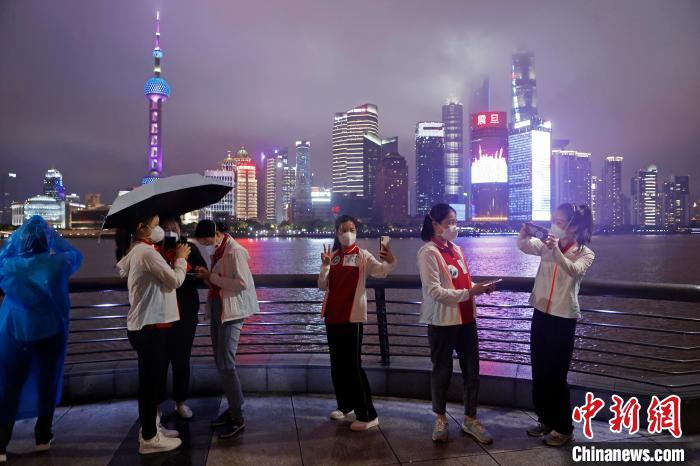 華中科技大學同濟醫(yī)學院附屬同濟醫(yī)院援滬醫(yī)療隊隊員冒雨在外灘濱江步道上合影?！∫罅⑶?攝