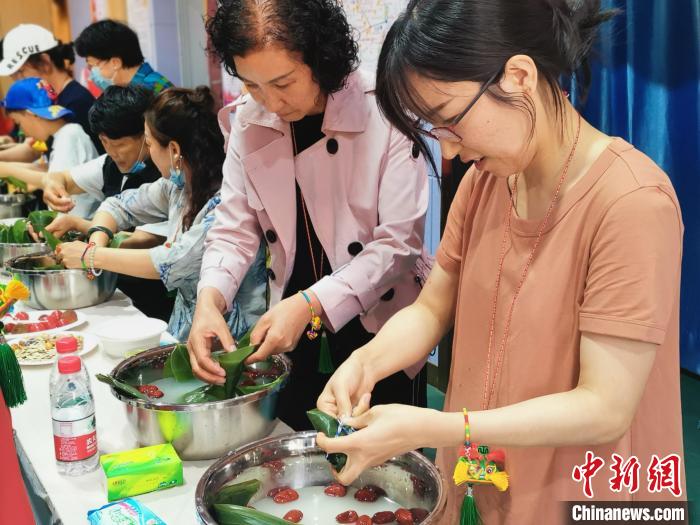 在寧港澳臺同胞與社區(qū)居民一起包粽子?！幭母郯呐_辦 供圖