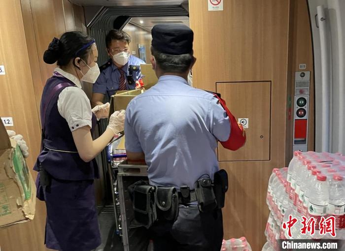 乘警與列車工作人員一起運(yùn)送礦泉水?！⌒熘蓁F路公安處供圖