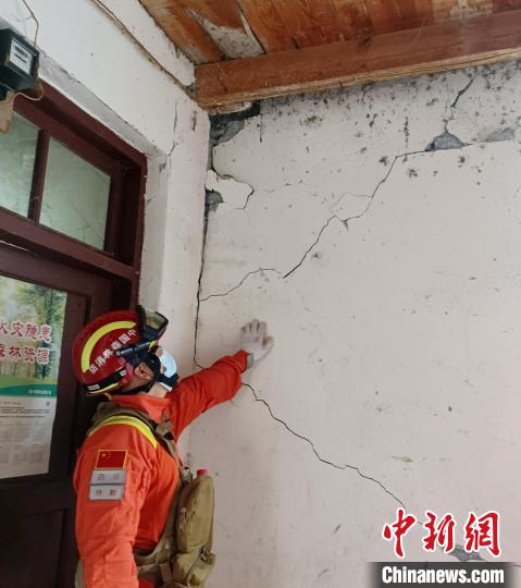 森林消防員現(xiàn)場查看開裂的墻體。　曾鵬 攝