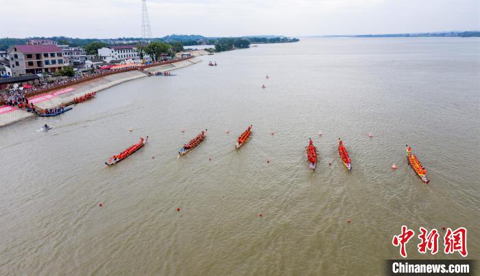 圖為參賽的龍舟隊(duì)伍在贛江之上劈波斬浪，奮力向前，岸邊擠滿了前來觀賽的民眾?！∏裾?攝