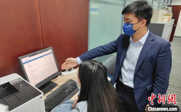 圖為廈門銀行員工指導(dǎo)臺商通過金服云平臺申請“臺企快服貸”?！＄娦?攝