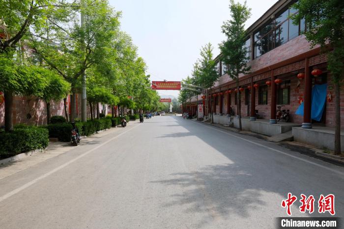 前南峪村干凈整潔、綠樹成蔭的街道，路兩側是村民住的二層樓房?！堸i翔 攝