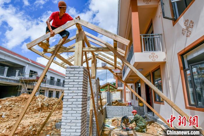 圖為海南省保亭黎族苗族自治縣什玲鎮(zhèn)(水賢村、什東村)生態(tài)搬遷安置區(qū)項(xiàng)目施工現(xiàn)場(chǎng)，工人安裝入戶門樓?！●樤骑w 攝