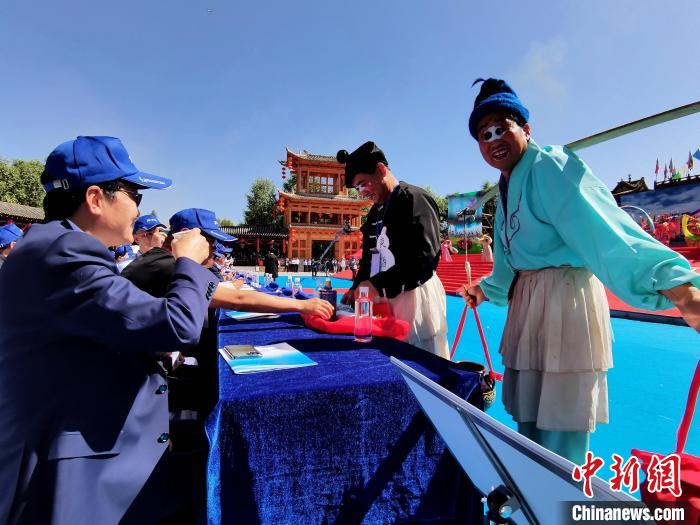 圖為前來參加開幕式的觀眾品嘗青稞酒?！∑钤鲚?攝