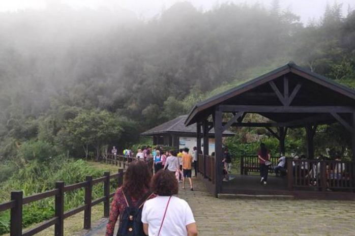熱浪襲人，近日嘉義縣山上景點(diǎn)涌入大量人潮，包括臺(tái)18線、臺(tái)3線沿途景點(diǎn)，阿里山森林游樂區(qū)都出現(xiàn)躲避山下高溫的游客。阿里山公路旁的隙頂午后山頂會(huì)飄下層層霧氣，相當(dāng)涼爽。圖片來源：臺(tái)灣“中央社”。