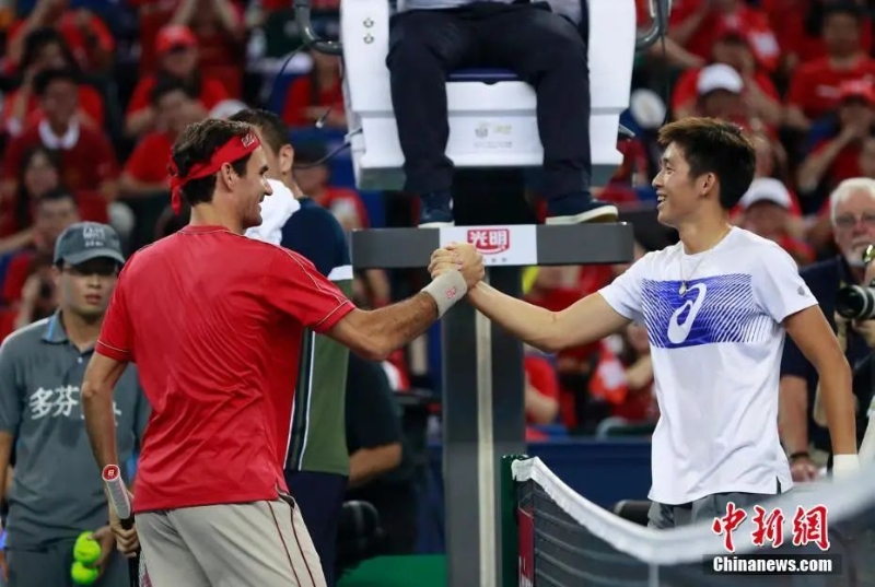 資料圖：網(wǎng)球名將費(fèi)德勒與中國(guó)球員華潤(rùn)豪握手致意。湯彥俊 攝