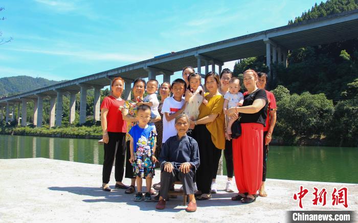 圖為唐二妹與部分家人在潯江邊合影?！钭谑?攝