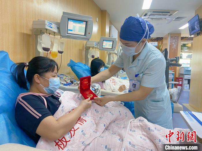 小學(xué)語文老師韋堅獲授“獻(xiàn)血百次紀(jì)念章”。　南寧市獻(xiàn)血辦供圖