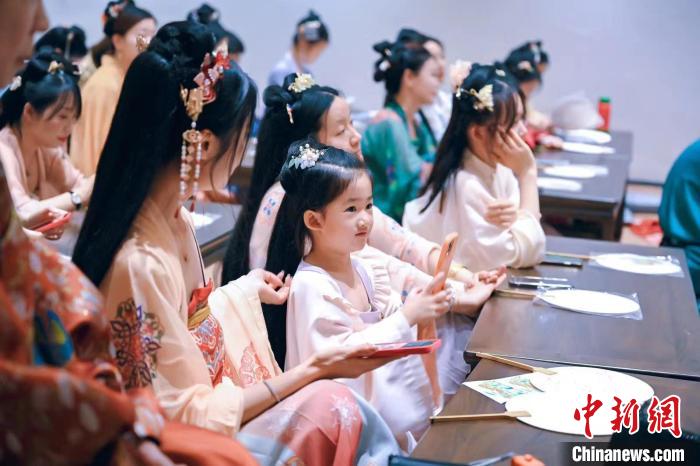 圖為游客在“宮宴”體驗傳統(tǒng)文化。　宮宴供圖