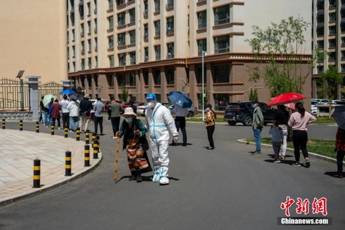 圖為8月12日，拉薩一小區(qū)內，工作人員攙扶藏族老人進行核酸檢測。 江飛波 攝