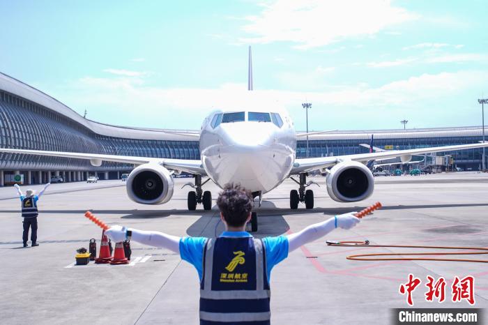 圖為機(jī)務(wù)人員引導(dǎo)飛機(jī)?？??！￡惞谘?攝