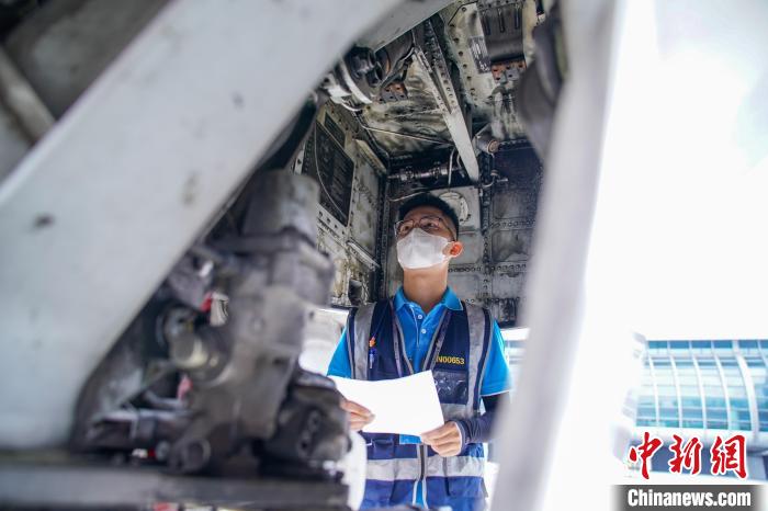 圖為航線維護(hù)工程師對(duì)飛機(jī)進(jìn)行檢查。　陳冠言 攝