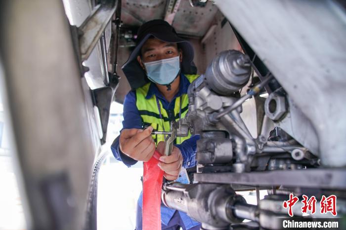 圖為放行工程師在飛機(jī)前起落架插上轉(zhuǎn)彎銷(xiāo)。　陳冠言 攝