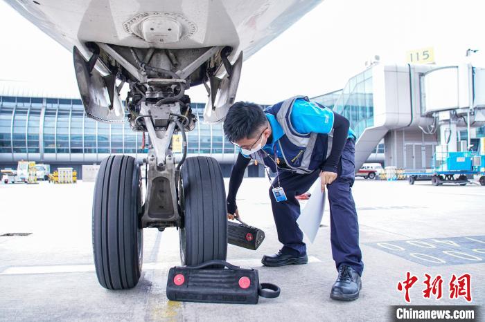 圖為航線維護(hù)工程師擺放輪擋?！￡惞谘?攝