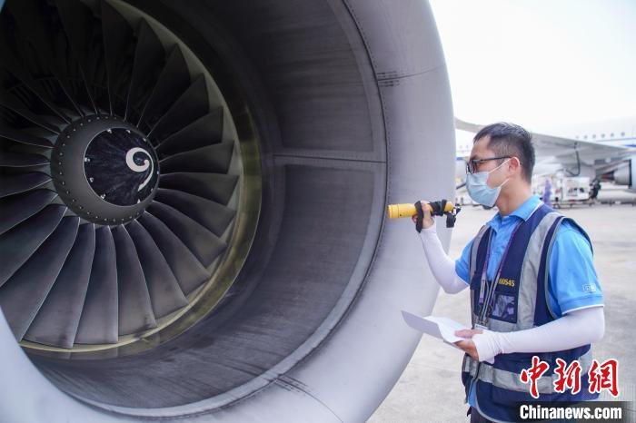 圖為航線維護(hù)工程師對(duì)飛機(jī)發(fā)動(dòng)機(jī)進(jìn)行檢查。　陳冠言 攝