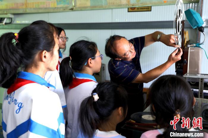 圖為肖光合向參觀的學生演示老式放映機的使用?！∩筹w 攝