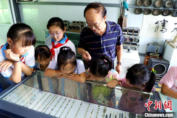 圖為肖光合正在給孩子們介紹收音機上的零件和電路原理。　沙飛 攝