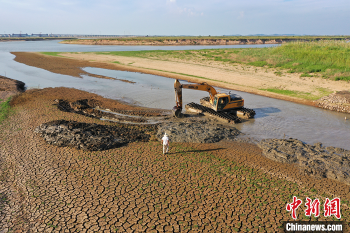 圖為8月23日，在鄱陽湖畔的江西省南昌市進(jìn)賢縣三里鄉(xiāng)六零圩，施工負(fù)責(zé)人正在指揮挖渠蓄水的挖掘機(jī)操控人員。（無人機(jī)照片） <a target='_blank' href='/'>中新社</a>記者 劉占昆 攝